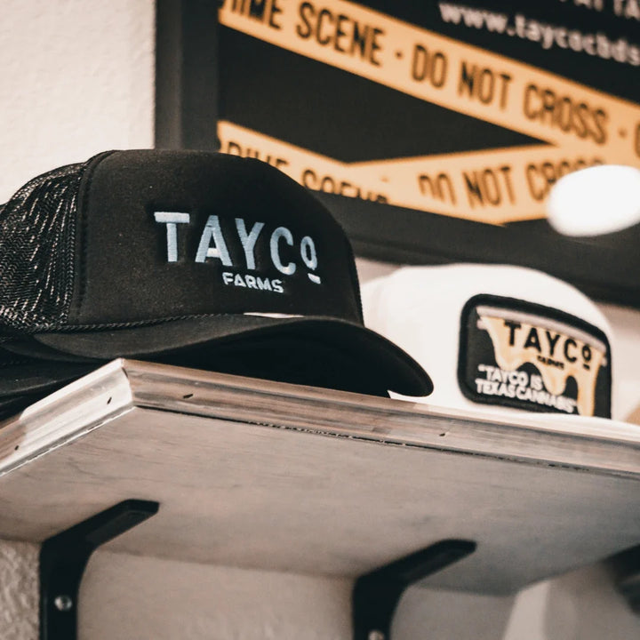 Tayco Farms branded caps on a display counter