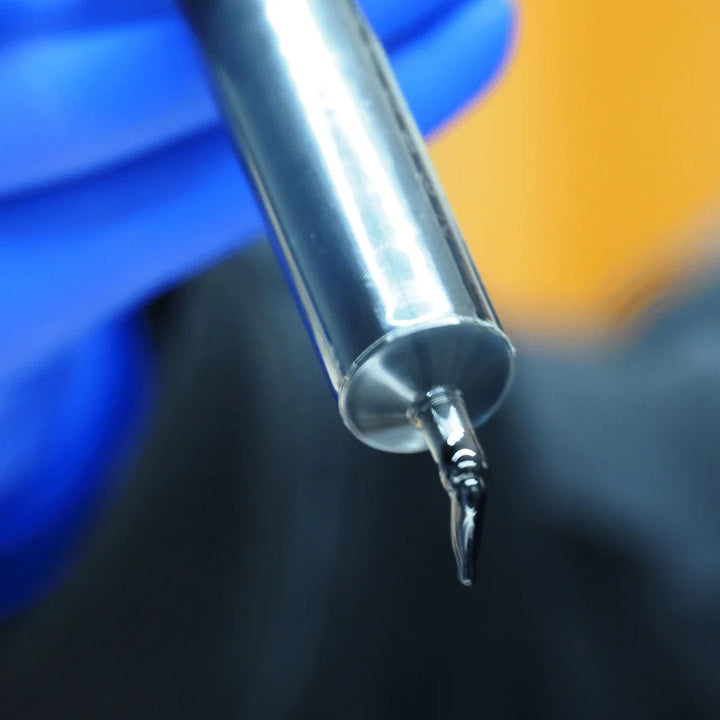 Gloved hand holding a syringe with hemp extract